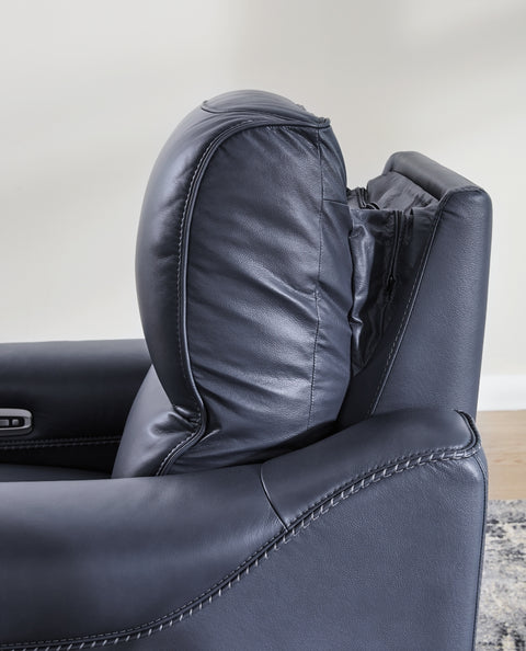Close-up of a dark gray leather recliner chair with visible stitching.