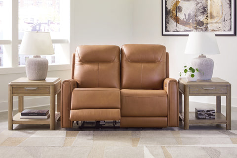 Brown leather recliner in a living room setting with side tables and decor.